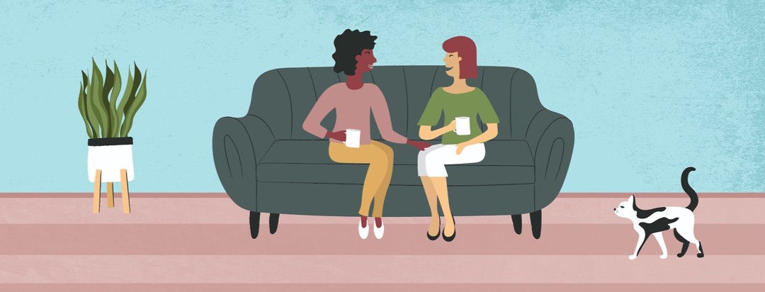 Two woman sitting on a couch talking