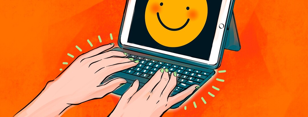 Hands typing at an ipad with a smiling face on screen