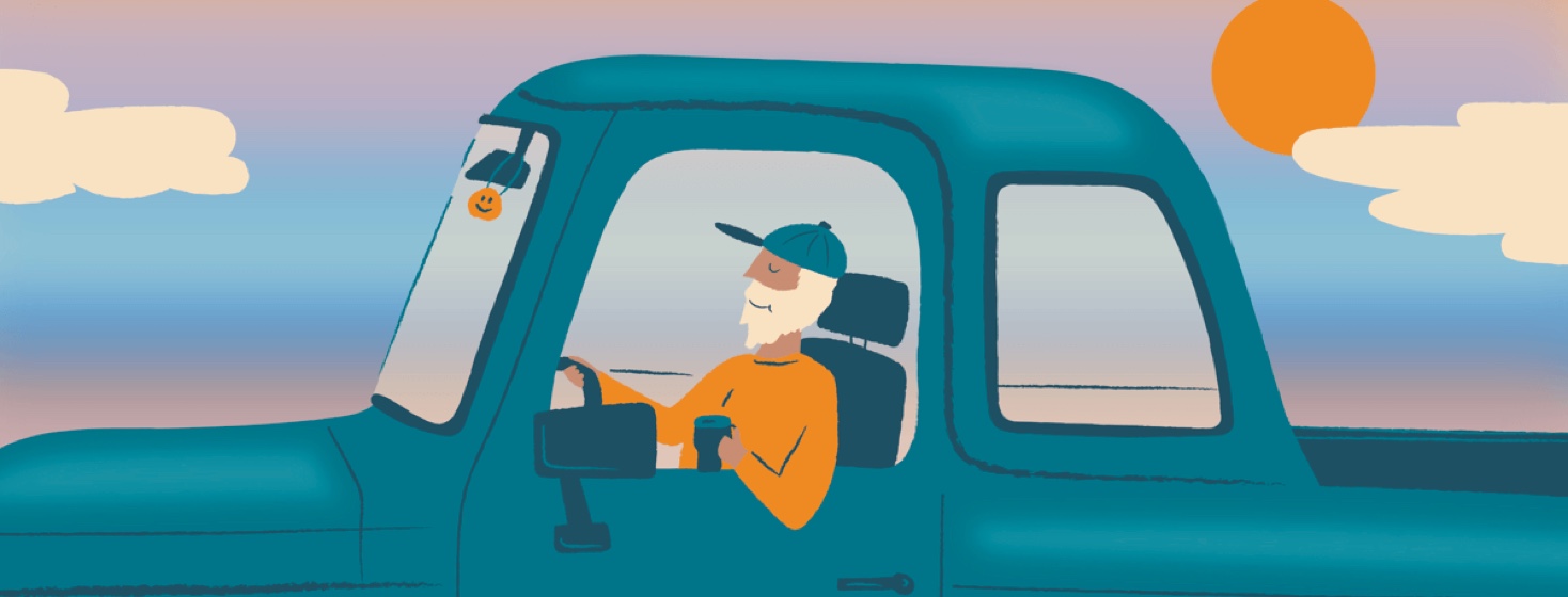 A relaxed man driving a truck in the sunset