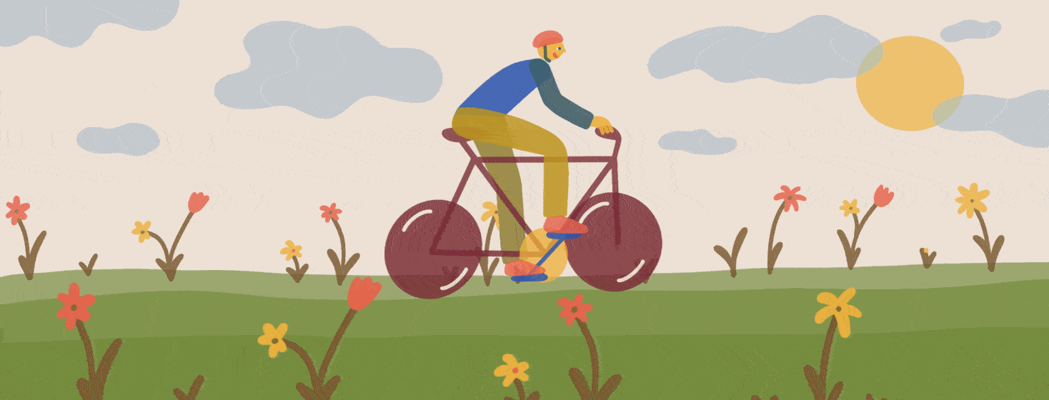 A man happily biking through a field of flowers on a sunny day.