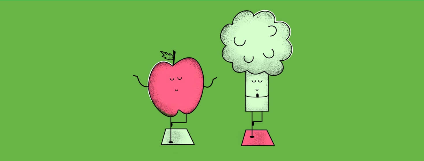 An apple and a broccoli practice tree pose on yoga mats.