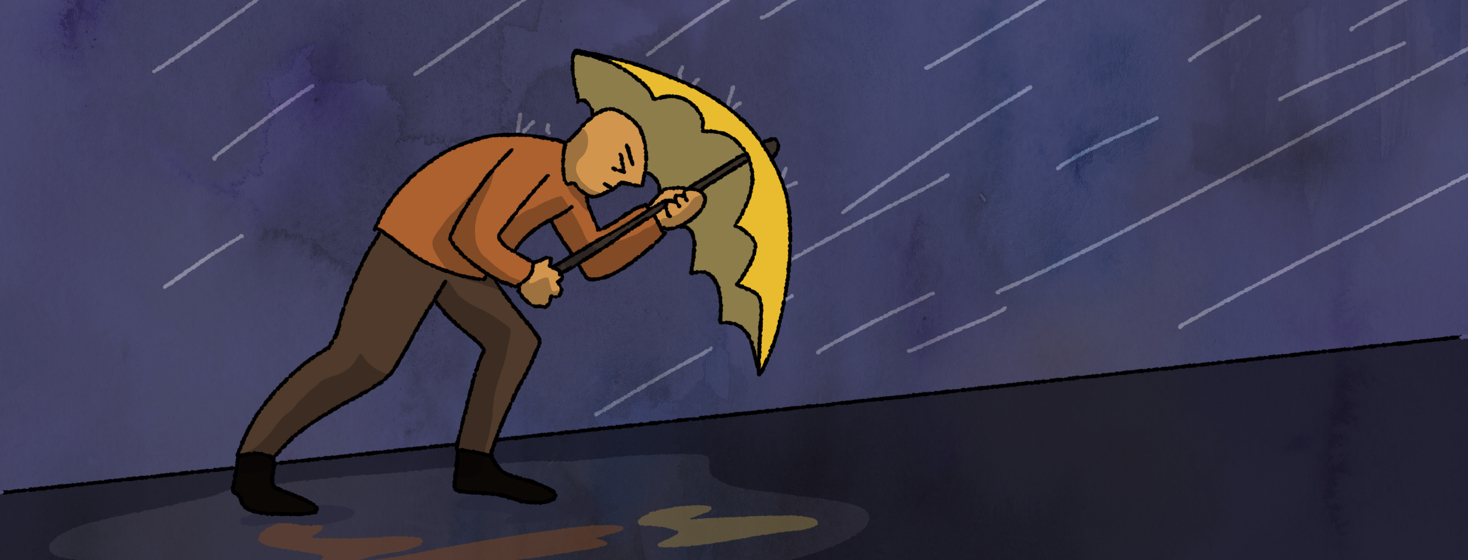A man walking uphill in a rainstorm against the wind
