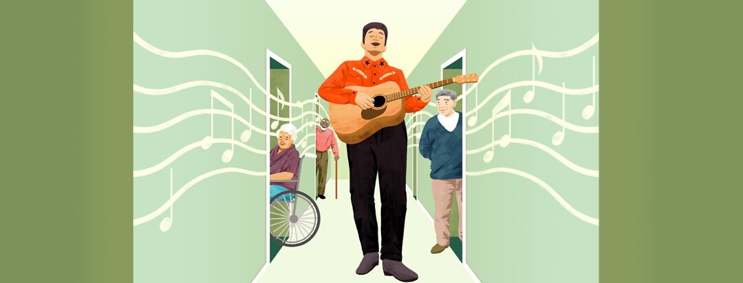 A man singing and playing guitar walks down the hallway of a care home